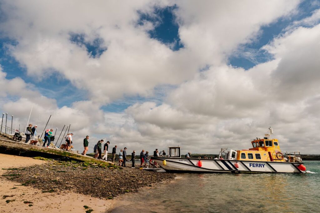 Passengers waiting on a jetty to board a small ferry