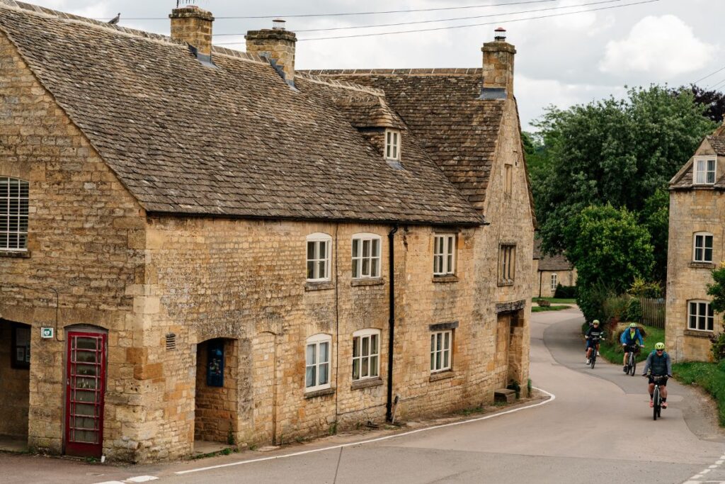Cyclists riding through a village in the Cotswolds