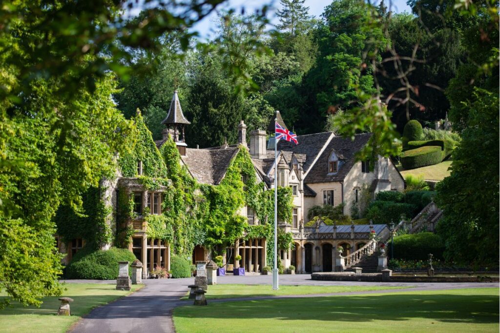 The exterior of the Manor House Castle Combe, with Union Jack flag fluttering in the breeze
