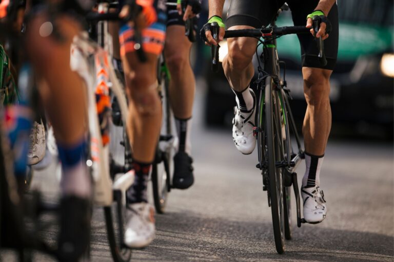 Legs of racing cyclists, including one out of the saddle