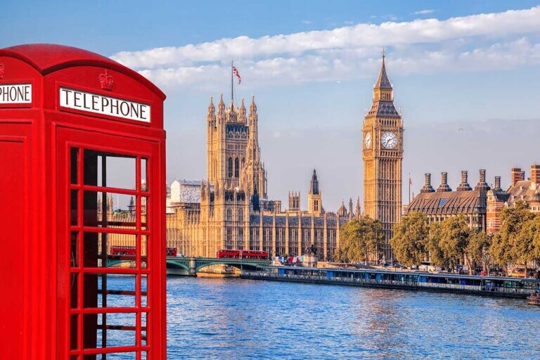 View across the River Thames of Big Ben and Westminster, London with a classic British red telephone box in foreground